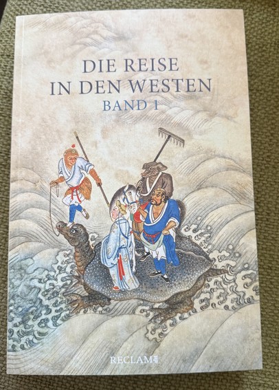 Foto eines Buches:
DIE REISE IN DEN WESTEN. BAND 1. Reclam. 
Auf dem Cover vier chinesische Märchenfiguren und ein Pferd auf einer Schildkröte.