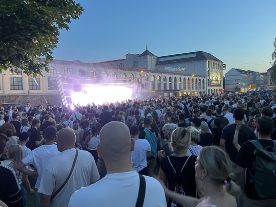 Club Stage beim Kosmos-Festival in Chemnitz. Man sieht eine kleine Bühne mit sehr vielen tanzenden Menschen davor. Im Hintergrund die Ermafa-Passage.