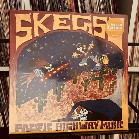 Albumcover für "Pacific Highway Music" von Skegs mit bunten, cartoonartigen Illustrationen einer Rakete, Kakteen und Skeletten. Das Design enthält den Text "LIMITED EDITION" und zeigt einen lebendigen, skurrilen Stil.