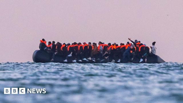 Migrants sit on a dinghy as it prepares to sail into the English Channel on 10 July 2025 in Gravelines, France.