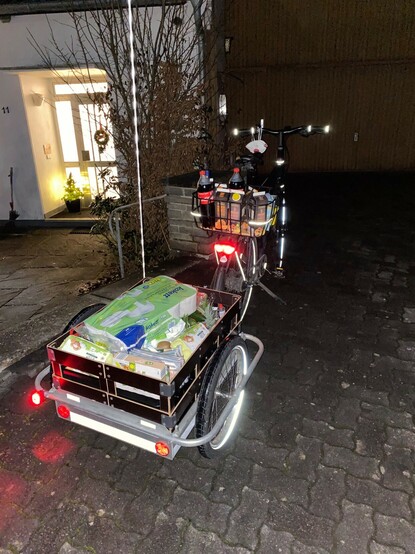 voll beladener Lastenanhänger leuchtend und reflektierend bei Nacht