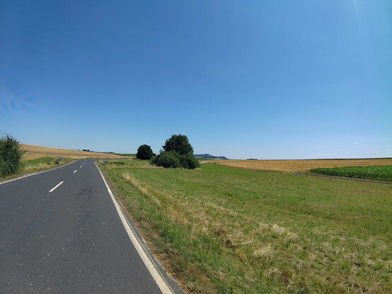 Leere Landstraße, die Amöneburg im Hintergrund am Horizont