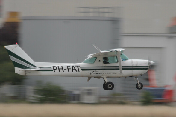 A Cessna 150 single-engine high-wing light aircraft just before touchdown