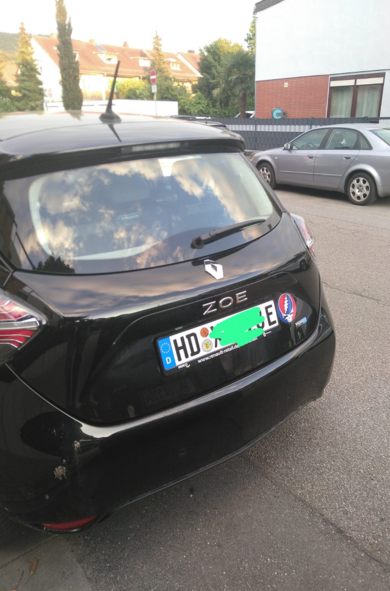 A parking black Renault Zoe car with a sticker of Greatful Dead