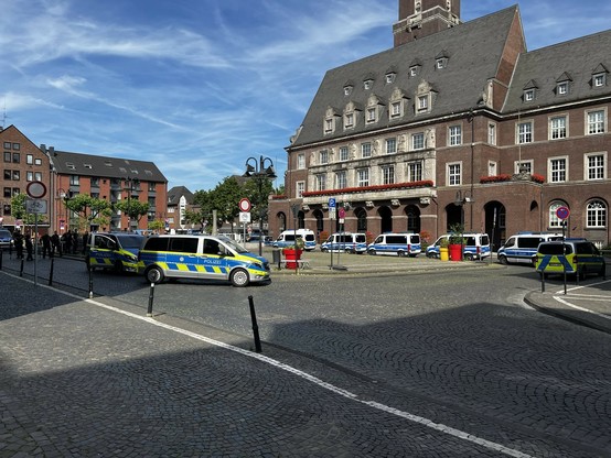 Etwa 10 Polizei-Transporter und mehrere Beamt:innen auf dem Bottroper Rathausplatz