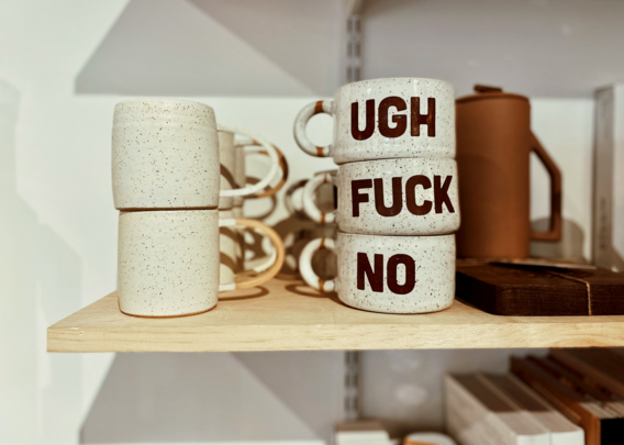 Foto von Tassen in einem Regal

auf drei übereinandergestapelten Tassen steht jeweils ein Wort - von oben nach unten:

UGH
FUCK
NO