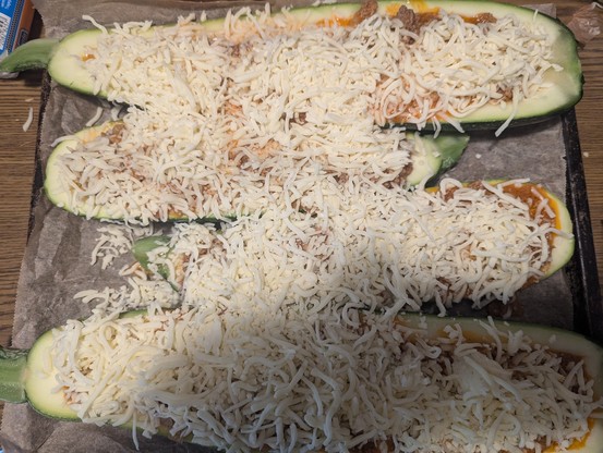 2 halbierte Zucchini mit Mozzarella bestreut