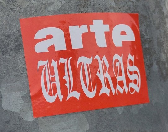 Sticker auf einem Pfosten mit der Aufschrift „arte Ultras“