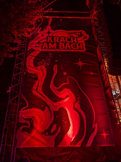 Krach am Bach Banner nachts rot angestrahlt.