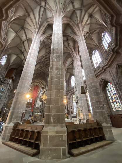 Sitzbänke mit Kopf-Schulterhaltern in der Lorenzkirche Nürnberg zwischen Pfeilern, die aussehen wie ein Freefall Tower