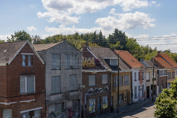 Straße mit Hausreihe. Die Häuser sind verlassen und voller Graffiti