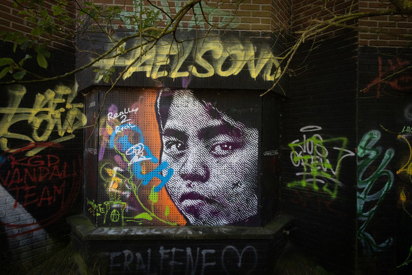 Graffiti an einer Wand. Unter anderem ein Gesicht