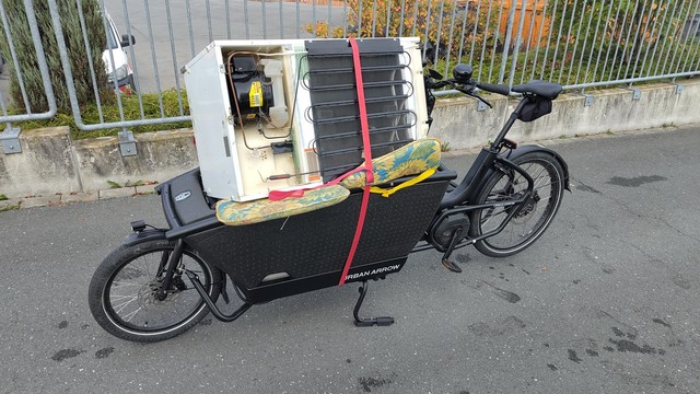 Lastenrad Urban Arrow mit ausgedientem Kühlschrank beladen auf dem Weg zum Bauhof, zur Entsorgung