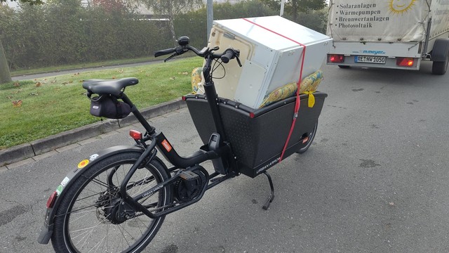 Lastenrad Urban Arrow mit ausgedientem Kühlschrank beladen auf dem Weg zum Bauhof, zur Entsorgung