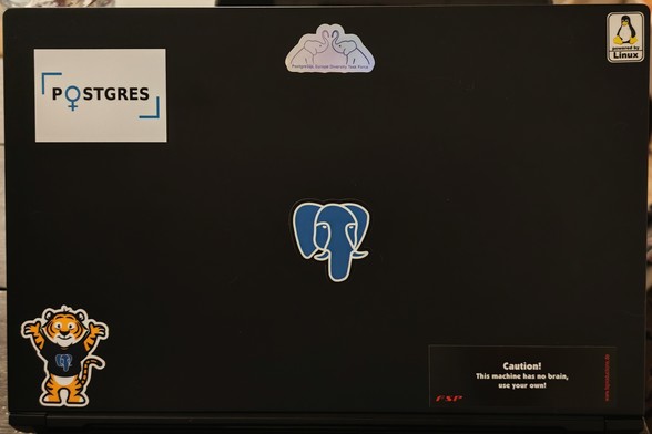 Laptop lid with some stickers and a new one: The PostgreSQL Europe Diversity Task Force sticker