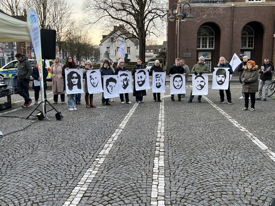 Kundgebungsteilnehmende mit Bildern von Gökhan Gültekin, Sedat Gürbüz, Said Nesar Hashemi, Mercedes Kierpacz, Hamza Kurtović, Vili Viorel Păun, Fatih Saraçoğlu, Ferhat Unvar und Kaloyan Velkov
