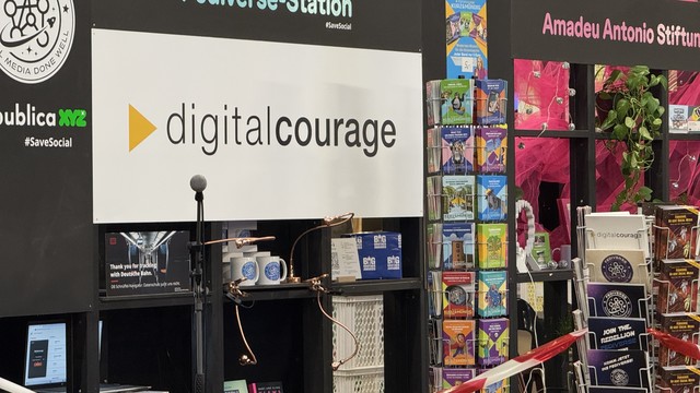 Das Bild zeigt den Messestand von Digitalcourage auf der re:publica 2025. Zu sehen ist:
	•	ein großes Digitalcourage-Logo mit gelbem Pfeil
	•	ein Schild mit der Aufschrift „Fediverse-Station“ und dem Hashtag #SaveSocial
	•	eine Infowand mit Materialien von Digitalcourage und der Amadeu Antonio Stiftung
	•	zahlreiche Kurz&Mündig-Broschüren in bunten Farben
	•	Aufsteller mit Flyern zu den BigBrotherAwards und zum Fediverse („Join the Rebellion“)
	•	ein Poster mit der Aufschrift: „Thank you for tracking with Deutsche Bahn. DB-Schnüffel-Navigator: Datenschutz juckt uns nicht.“
	•	Mikrofon und technisches Equipment für Vorträge oder Interviews

Der Stand wirbt deutlich für digitale Selbstbestimmung, Datenschutz und dezentrale soziale Netzwerke.