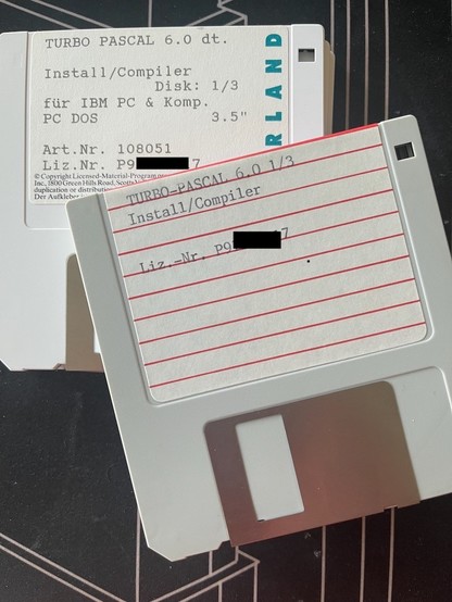 Two stacks of ancient 3,5" floppy disks: original 3 disk set of Turbo Pascal 6.0 below my set of backup copies. Backup copies meticiously labeled, using my dad's typewriter.