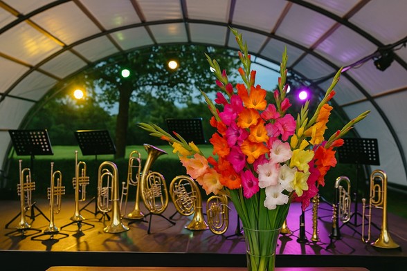 Bühne mit Blasinstrumenten und bunten Blumen im Vordergrund